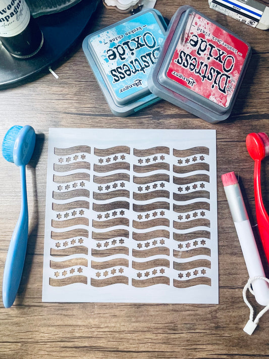 A sheet of nail stamping plates with wavy bacon strip designs and star patterns, displayed on a wooden surface with crafting tools including an ink pad, a blue brush, and a red roller.
