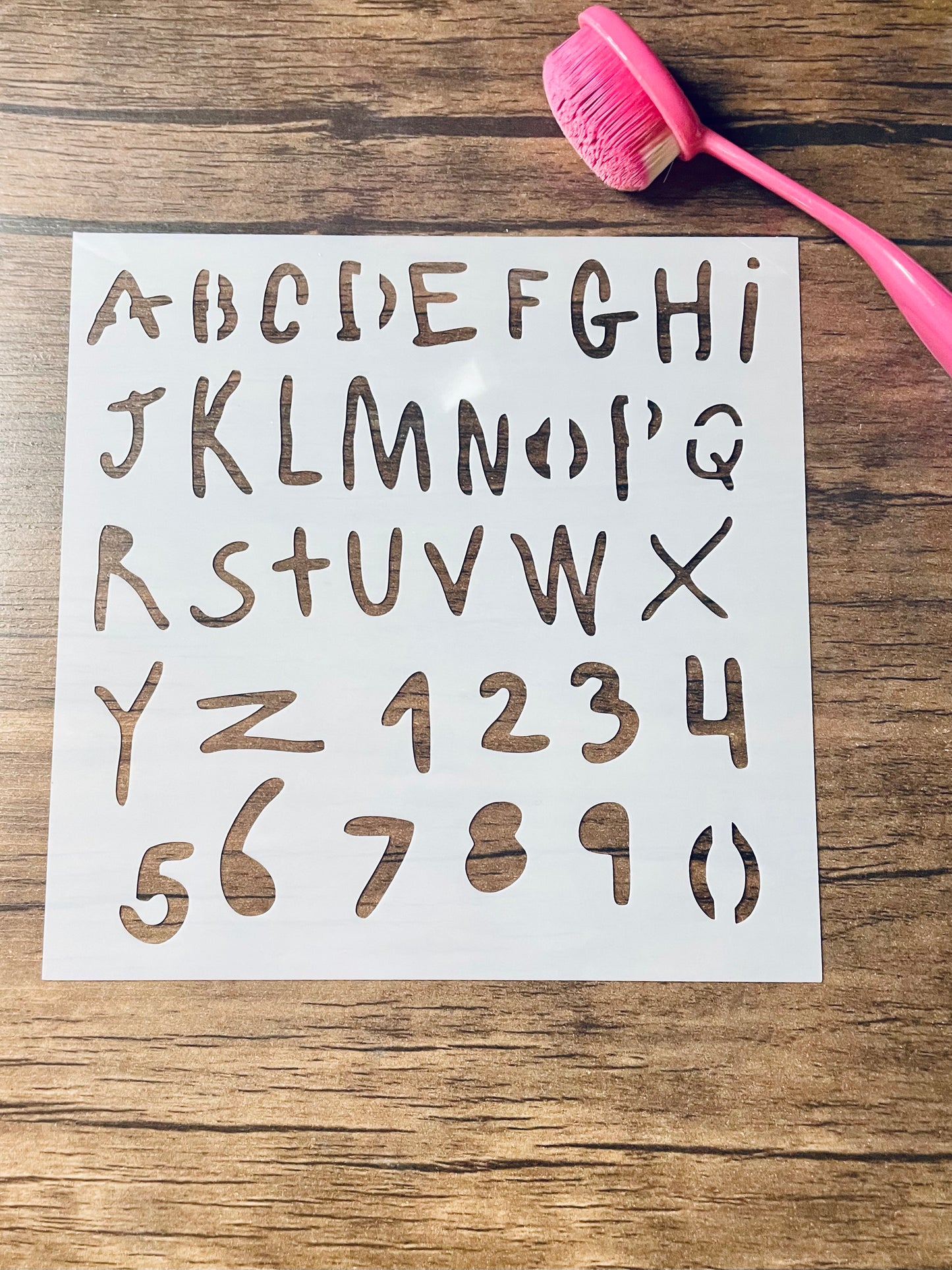 5.75” x 5.75” frosted stencil with Silhouettes of the letters a-z and numbers 0-9 in a shaky kids type handwriting 