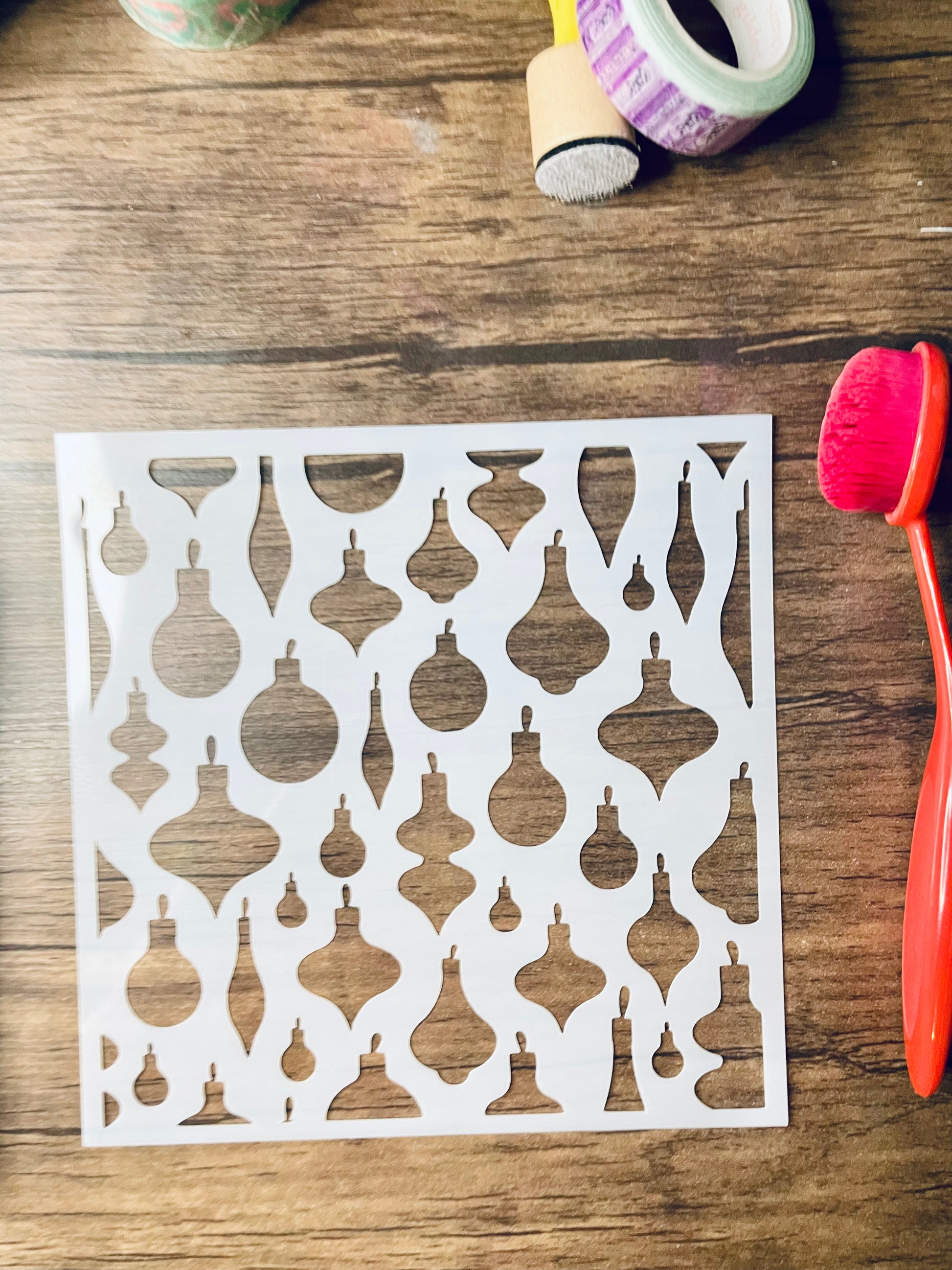 Decorative stencil withretro ornament pattern on a wooden surface with tools.